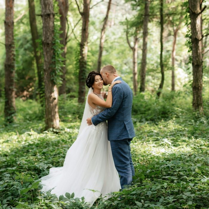 wedding walk of the bride and groom in the deciduous forest in summer